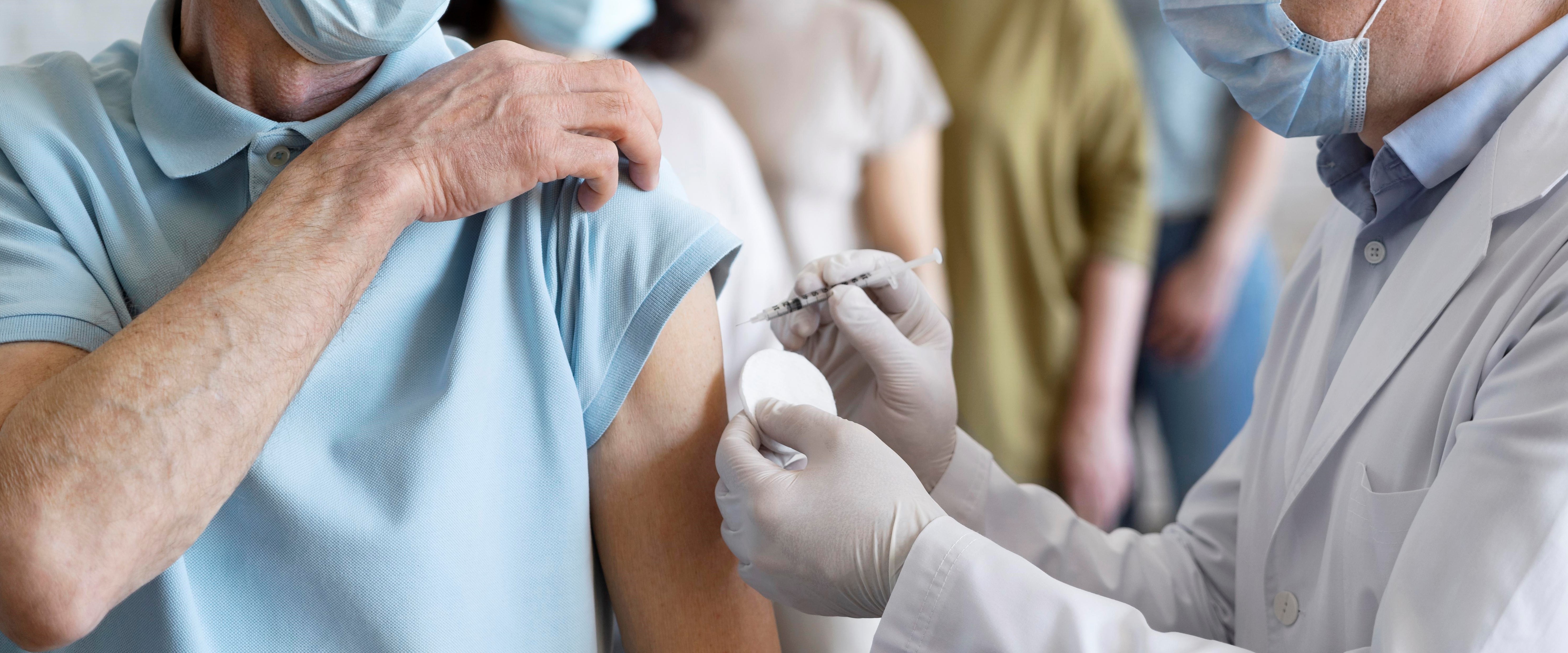 man-getting-vaccine-shot-by-doctor-with-medical-mask